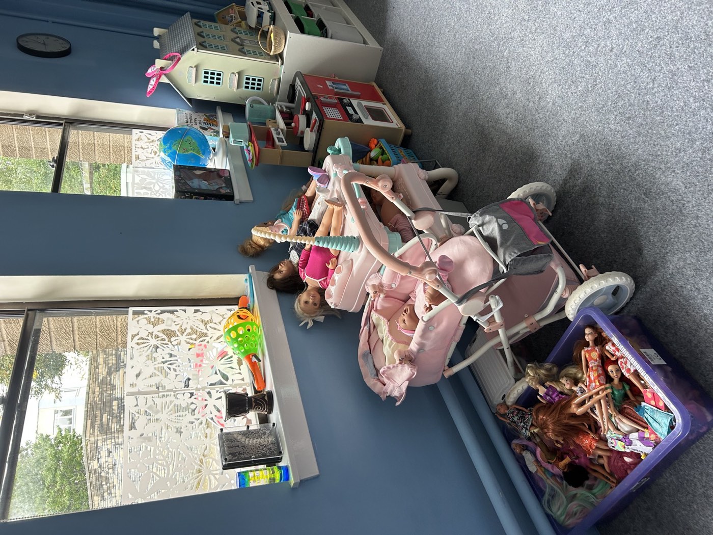Play therapy resources including dolls, a dolls' house, a toy kitchen and sensory bottles